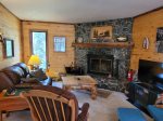Family room with wood fireplace, sofa and TV, games, puzzles